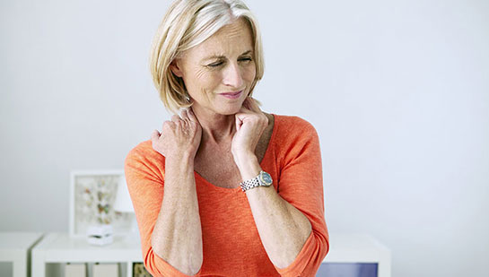 Mature woman suffering from neck and shoulder pain before visiting Cary chiropractor