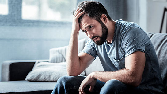 Man struggling with stress before seeking Cary chiropractor
