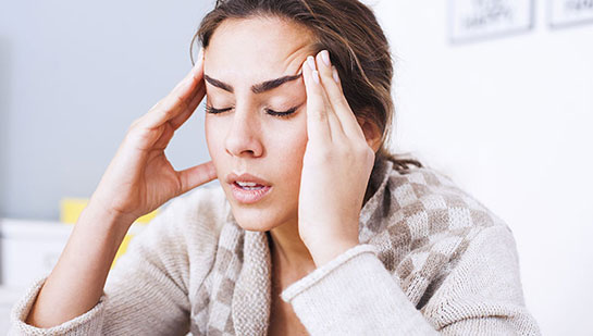 Woman suffering from headache before visiting Cary chiropractor