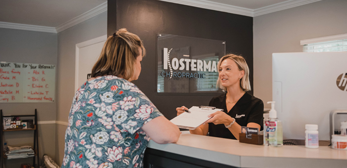 Patient receiving forms for chiropractic adjustment in Cary for pain relief